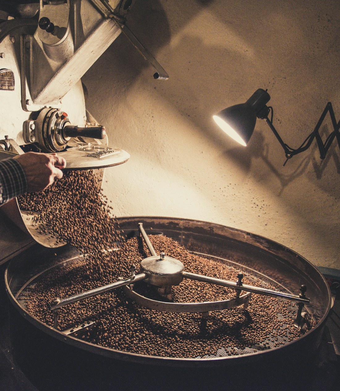 Coffee beans cooling in a roastery drum — quality-checked sourcing at origin